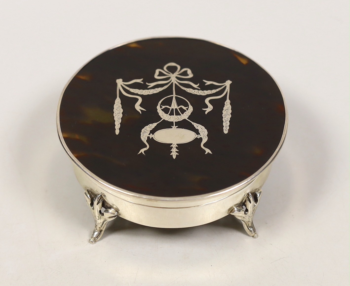 A George V silver and tortoiseshell piqué mounted circular trinket box, London, 1921, diameter 11.2cm.